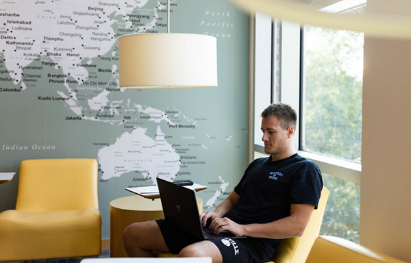 Student sitting in front of world map